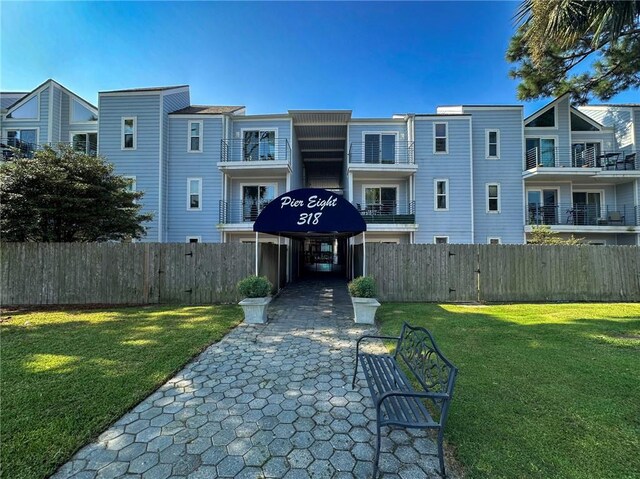 view of front of house with a balcony and a front yard