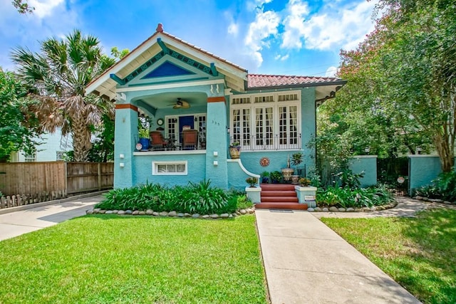 view of front facade featuring ceiling fan, a porch, and a front lawn