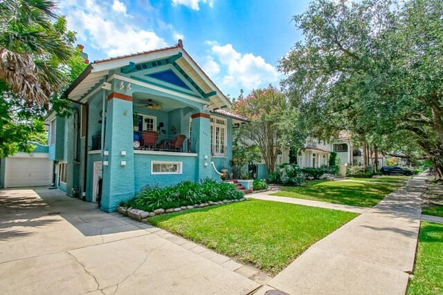 view of front of house with ceiling fan and a front yard