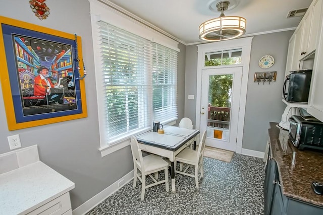 dining room featuring crown molding and a healthy amount of sunlight