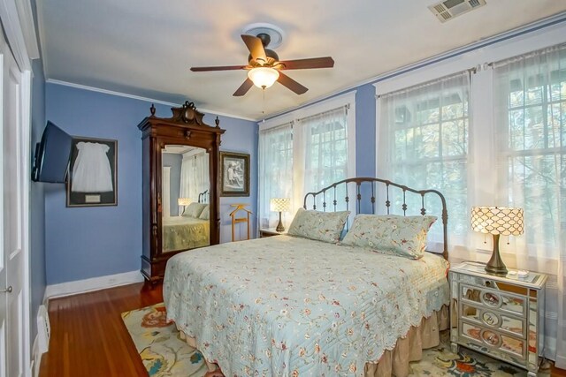 bedroom featuring ceiling fan, crown molding, and wood-type flooring