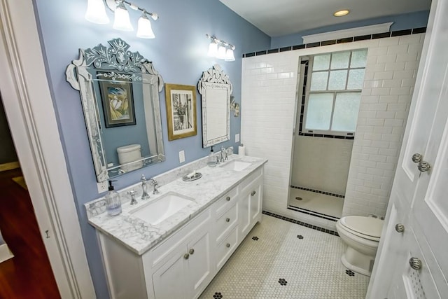 bathroom with dual vanity, toilet, a shower with door, and tile patterned flooring