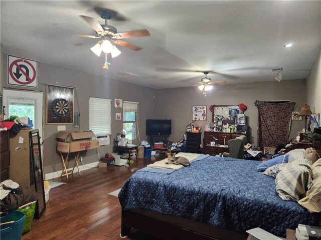 bedroom featuring multiple windows, dark wood-type flooring, and ceiling fan