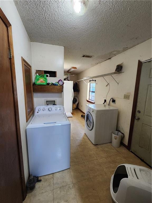 84653 Camus Ln, Covington, LA 70435 - washroom featuring washing machine and clothes dryer and a textured ceiling