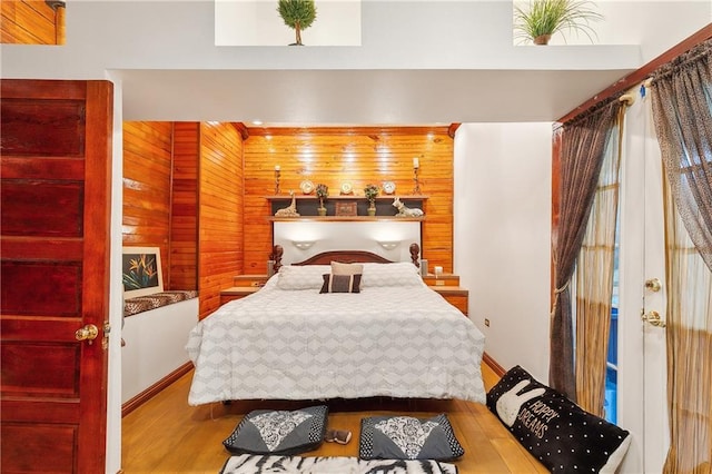 bedroom featuring wood-type flooring and wooden walls