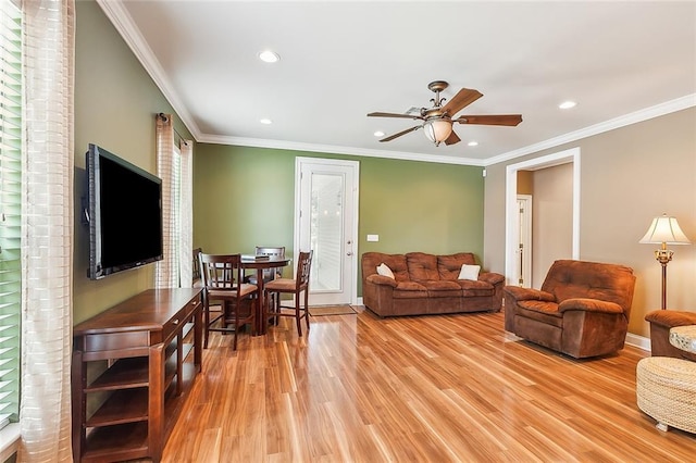 living room featuring ceiling fan, light hardwood / wood-style flooring, plenty of natural light, and ornamental molding