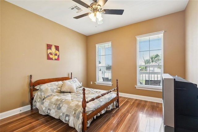 bedroom with ceiling fan and dark hardwood / wood-style flooring