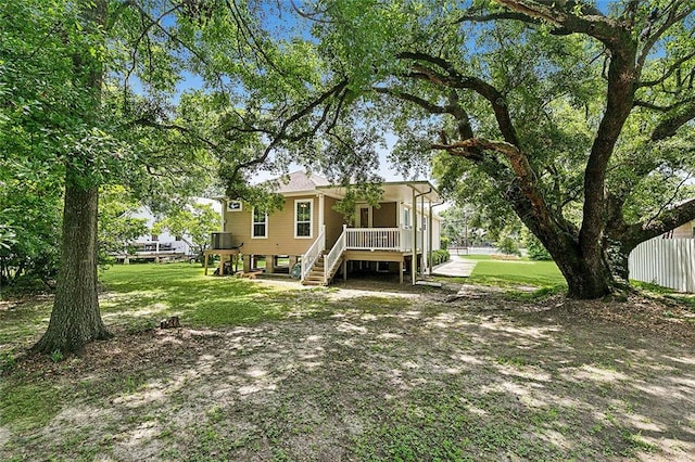 view of front of house with a front lawn, a deck, and central air condition unit