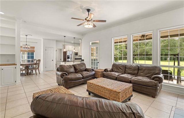 living room featuring ceiling fan with notable chandelier, light tile patterned floors, and crown molding