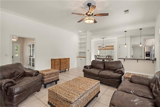 tiled living room featuring ornamental molding, french doors, and ceiling fan