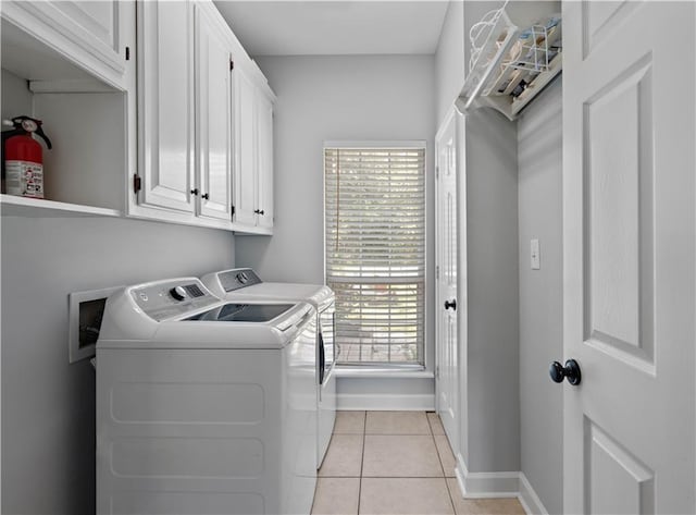 laundry area featuring cabinets, light tile patterned floors, and independent washer and dryer