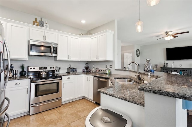 kitchen with light tile patterned floors, stainless steel appliances, white cabinetry, ceiling fan, and kitchen peninsula