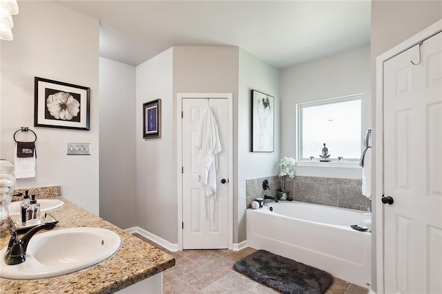 bathroom with dual vanity, tile patterned floors, and a bathtub