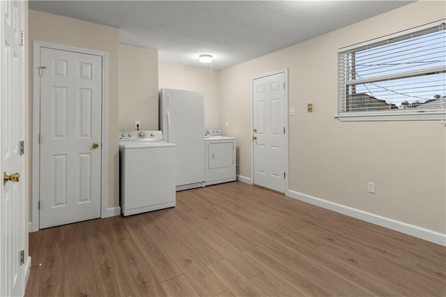 laundry area with light hardwood / wood-style floors and washer and dryer