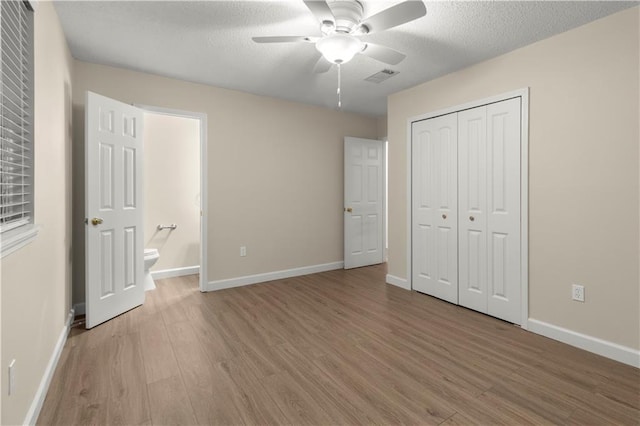 unfurnished bedroom featuring a textured ceiling, a closet, ceiling fan, and wood-type flooring