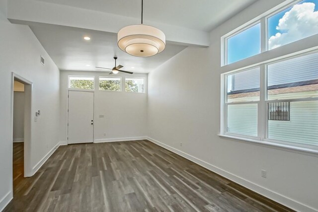 unfurnished dining area featuring ceiling fan, vaulted ceiling, and wood-type flooring