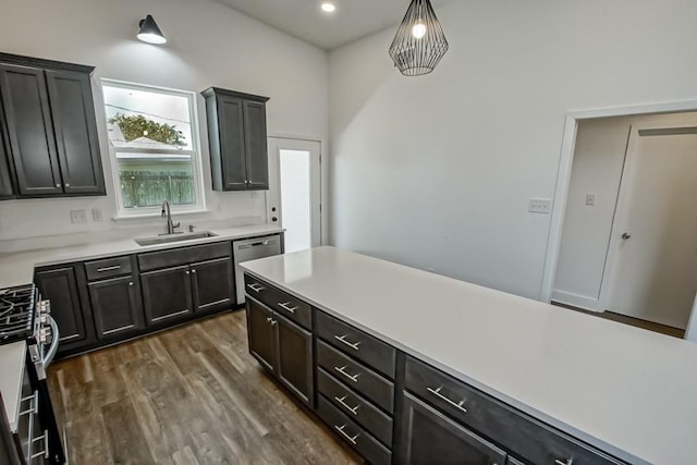 kitchen with sink, hanging light fixtures, dishwasher, range, and dark hardwood / wood-style flooring