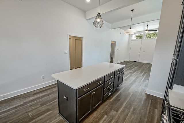 kitchen featuring dark wood-type flooring, beam ceiling, a center island, and hanging light fixtures