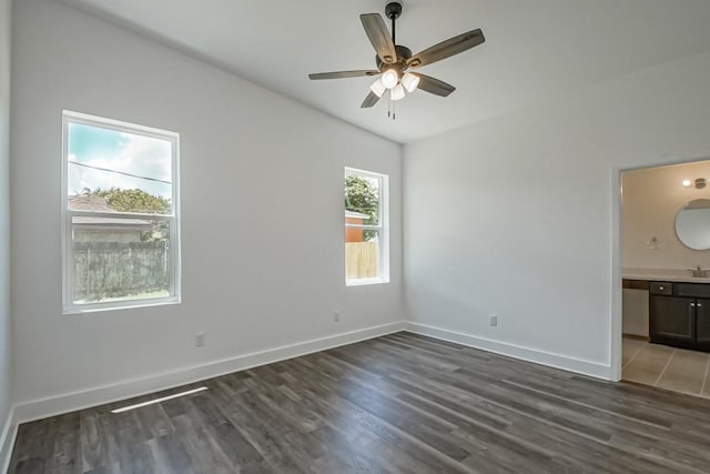 unfurnished room featuring ceiling fan, sink, and dark hardwood / wood-style flooring