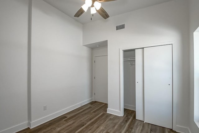 unfurnished bedroom featuring dark wood-type flooring, ceiling fan, and a closet