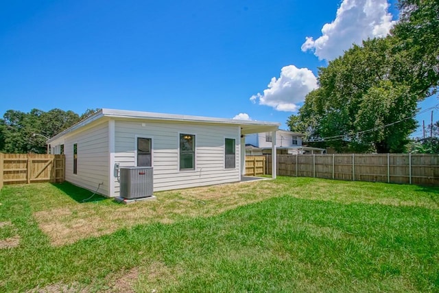 back of house with central AC and a lawn