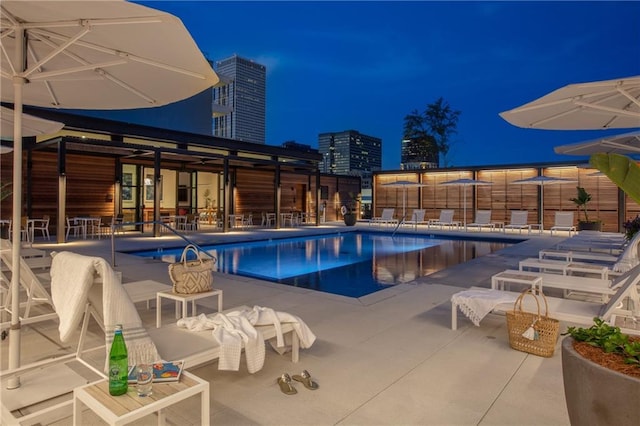 pool at twilight featuring a patio