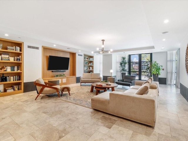 living room featuring french doors, an inviting chandelier, and built in shelves