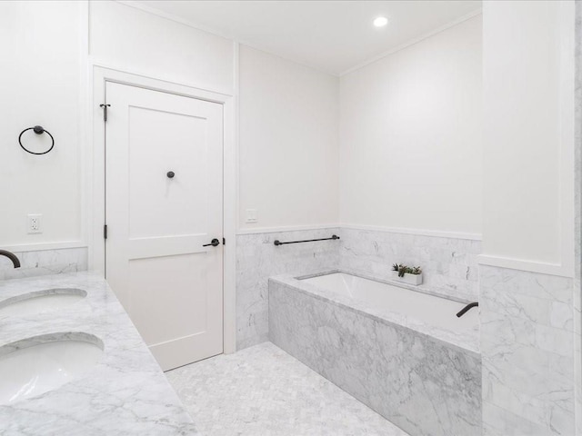 bathroom with vanity and a relaxing tiled tub