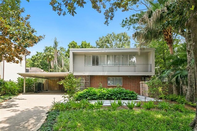 view of front of property featuring a balcony and a carport