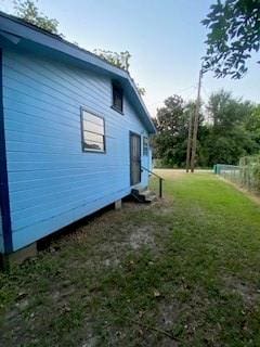 view of side of home with a yard