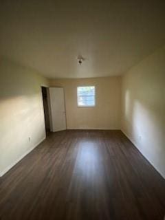 empty room with dark hardwood / wood-style flooring