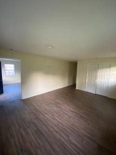 empty room with dark hardwood / wood-style flooring