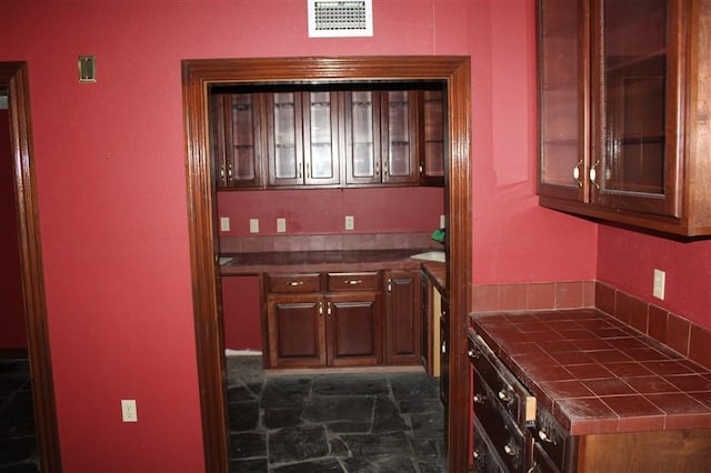 kitchen featuring dark tile patterned flooring and tile countertops