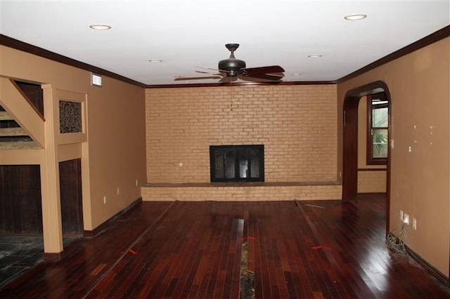 unfurnished living room featuring a brick fireplace, brick wall, and hardwood / wood-style flooring