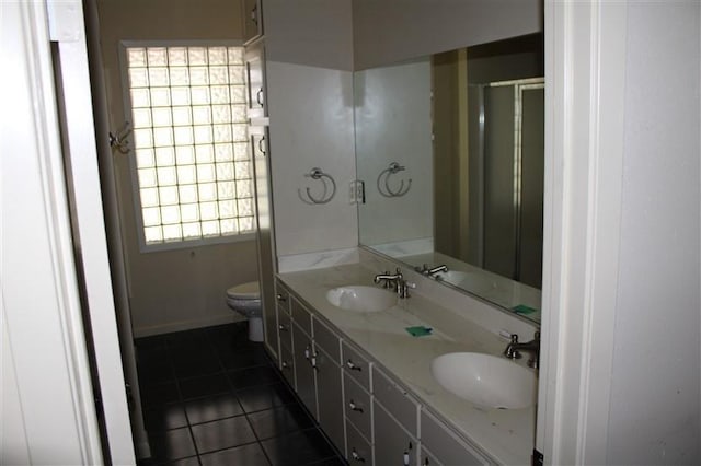 bathroom with double sink vanity, tile patterned floors, and toilet