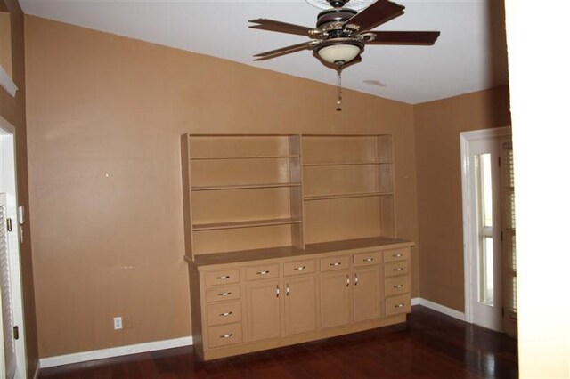 interior space with vaulted ceiling, cream cabinets, dark hardwood / wood-style flooring, and ceiling fan