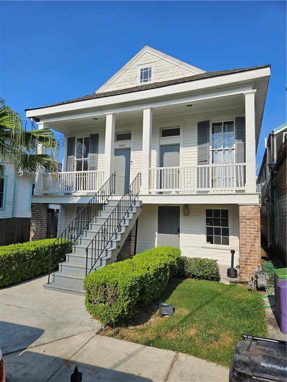 view of front of property featuring covered porch and stairway