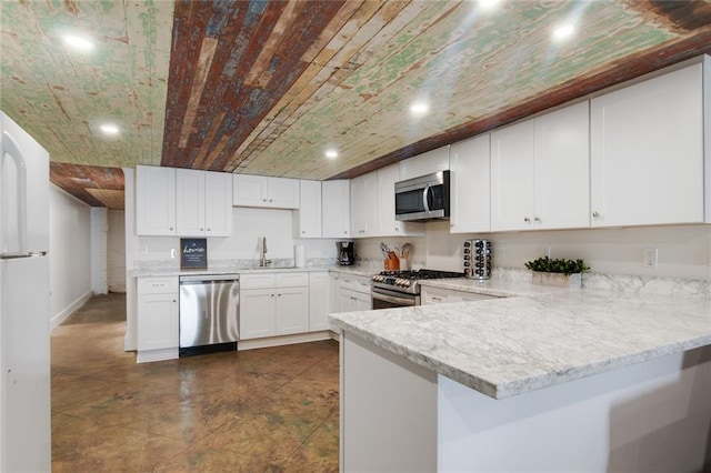 kitchen featuring stainless steel appliances, dark tile patterned floors, sink, white cabinets, and kitchen peninsula