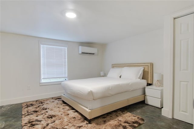 bedroom with concrete floors, baseboards, and an AC wall unit