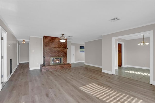 unfurnished living room featuring a brick fireplace, ornamental molding, and light hardwood / wood-style floors