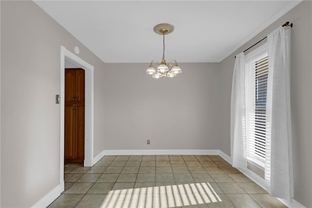 unfurnished room with light tile patterned flooring, an inviting chandelier, and a healthy amount of sunlight