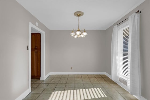 unfurnished room with a notable chandelier and light tile patterned floors