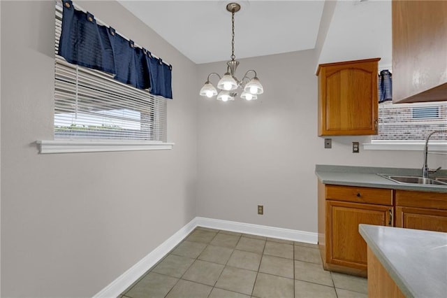 kitchen with light tile patterned floors, sink, hanging light fixtures, and a notable chandelier