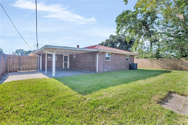 back of house with central air condition unit, a lawn, and a patio area