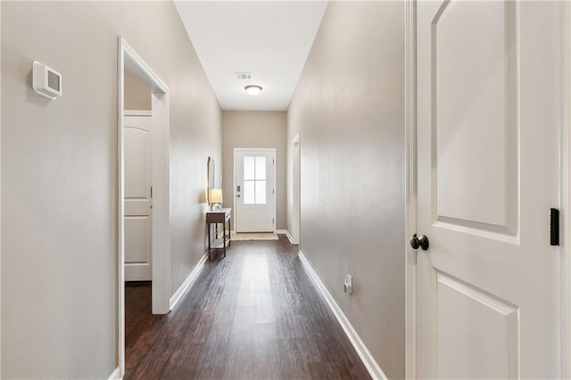 corridor with dark hardwood / wood-style flooring