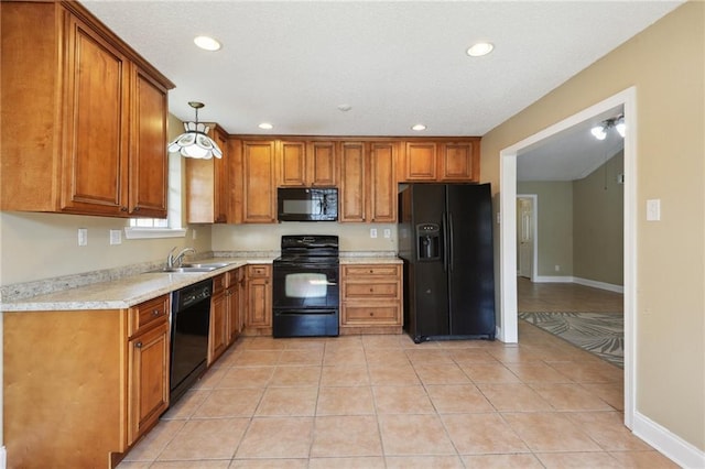 kitchen featuring light tile patterned floors, sink, hanging light fixtures, black appliances, and light stone countertops