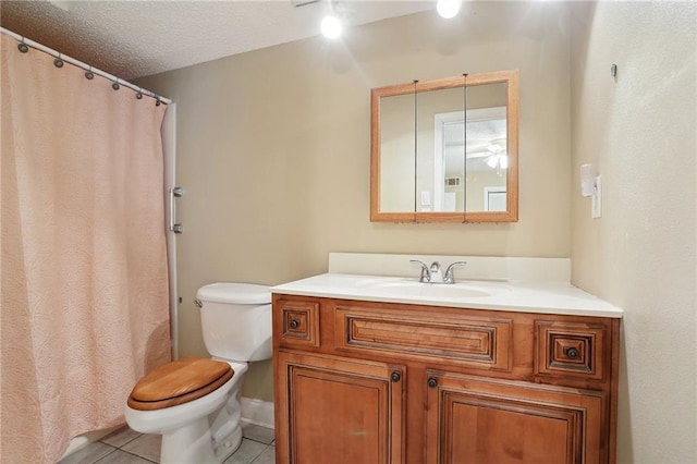 bathroom with vanity, toilet, tile patterned flooring, and a textured ceiling