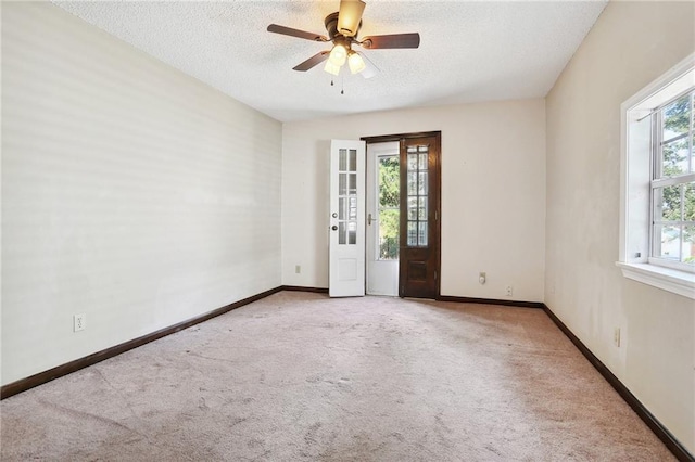 spare room featuring light carpet, ceiling fan, and a textured ceiling