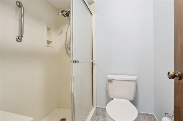 bathroom featuring walk in shower and toilet