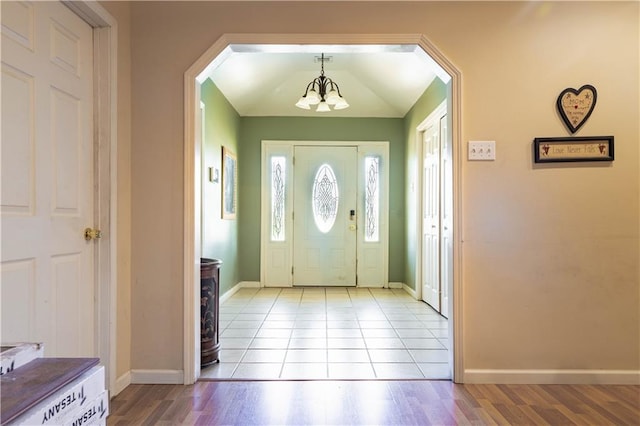 foyer entrance with light tile patterned floors and an inviting chandelier